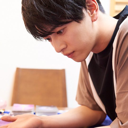 真剣な表情で鑑定士の話を聞く飯島さん