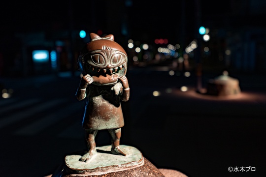 スポットで照らされた水木しげるロードのブロンズ像