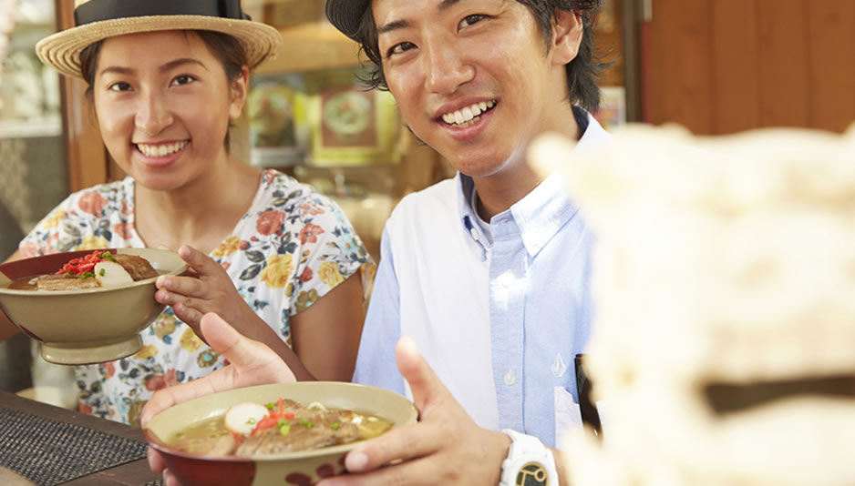 沖縄グルメ ソーキそばを食べる男女